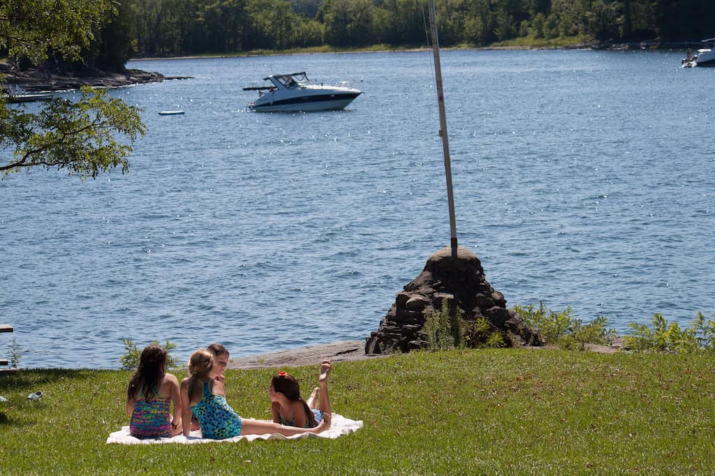Four kids sitting on a picnic blanket at Kingsland Bay State Park. 