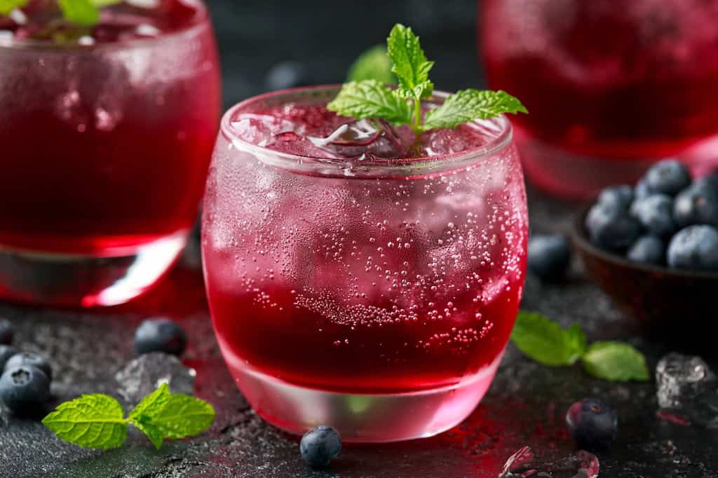 A refreshing blueberry cocktail with a sprig of mint. 