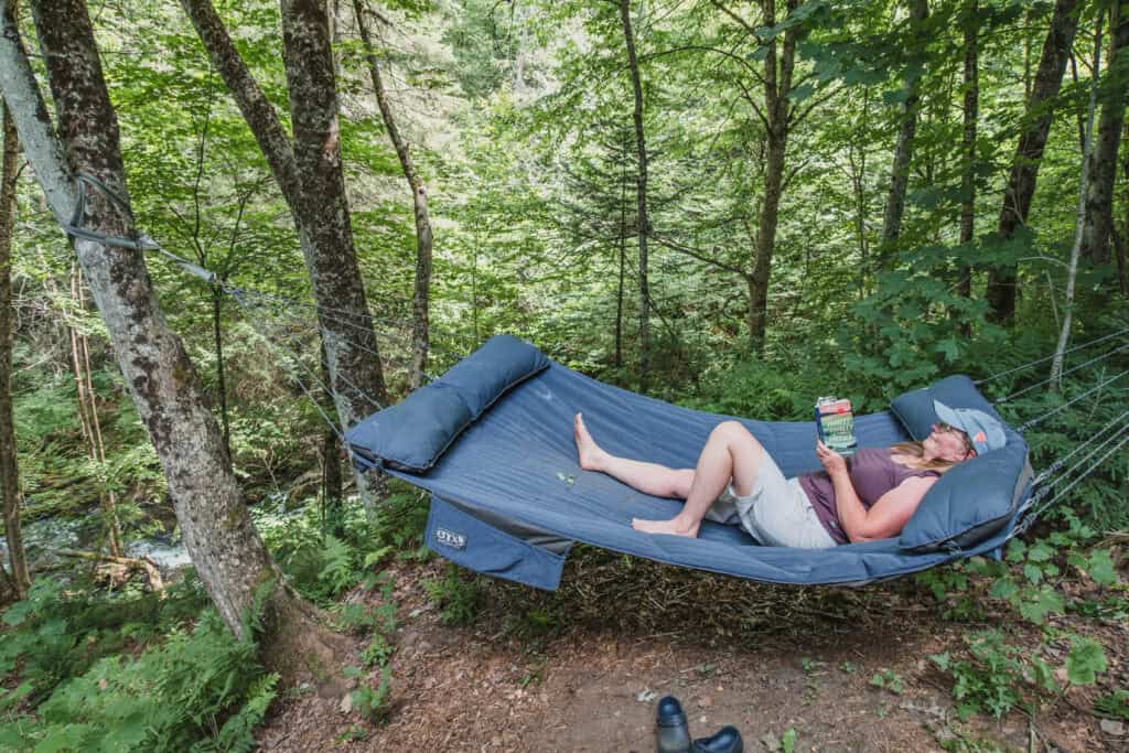 Tara lying in a hammock at Fallingwater Airstream. 