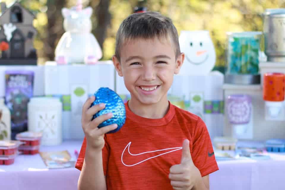 A young boy holds up a sparkly blue dinosaur egg at the Vermont Fairytale Festival.