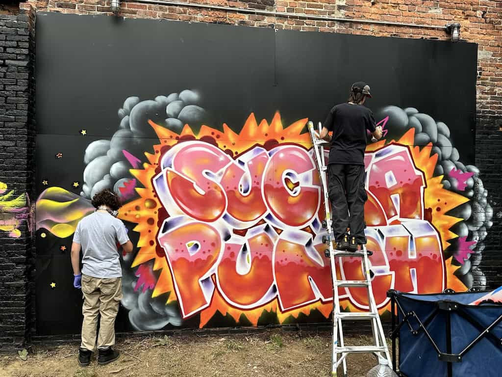 Sucka Punch Graffiti Jam painting in progress by Alexa Herrera Condry