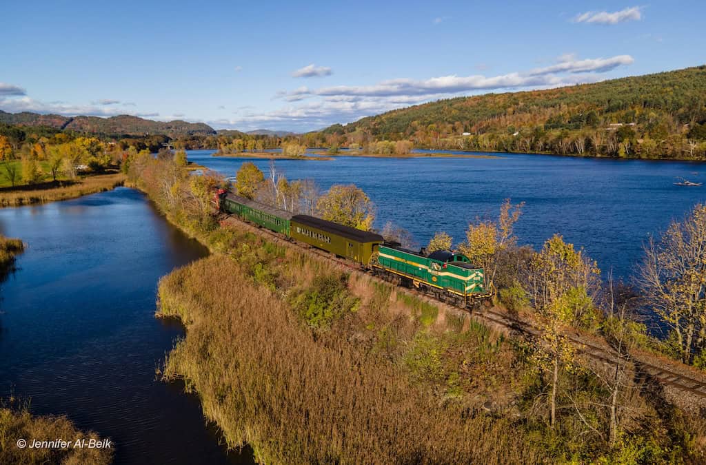 A train travels next to the Passumpsic River in St. Johnsbury.