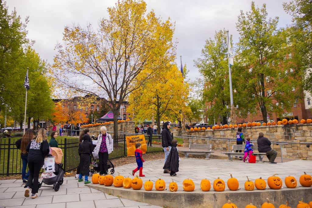 Kids walk through Rotary Park decorated with jack-o'-lanterns.